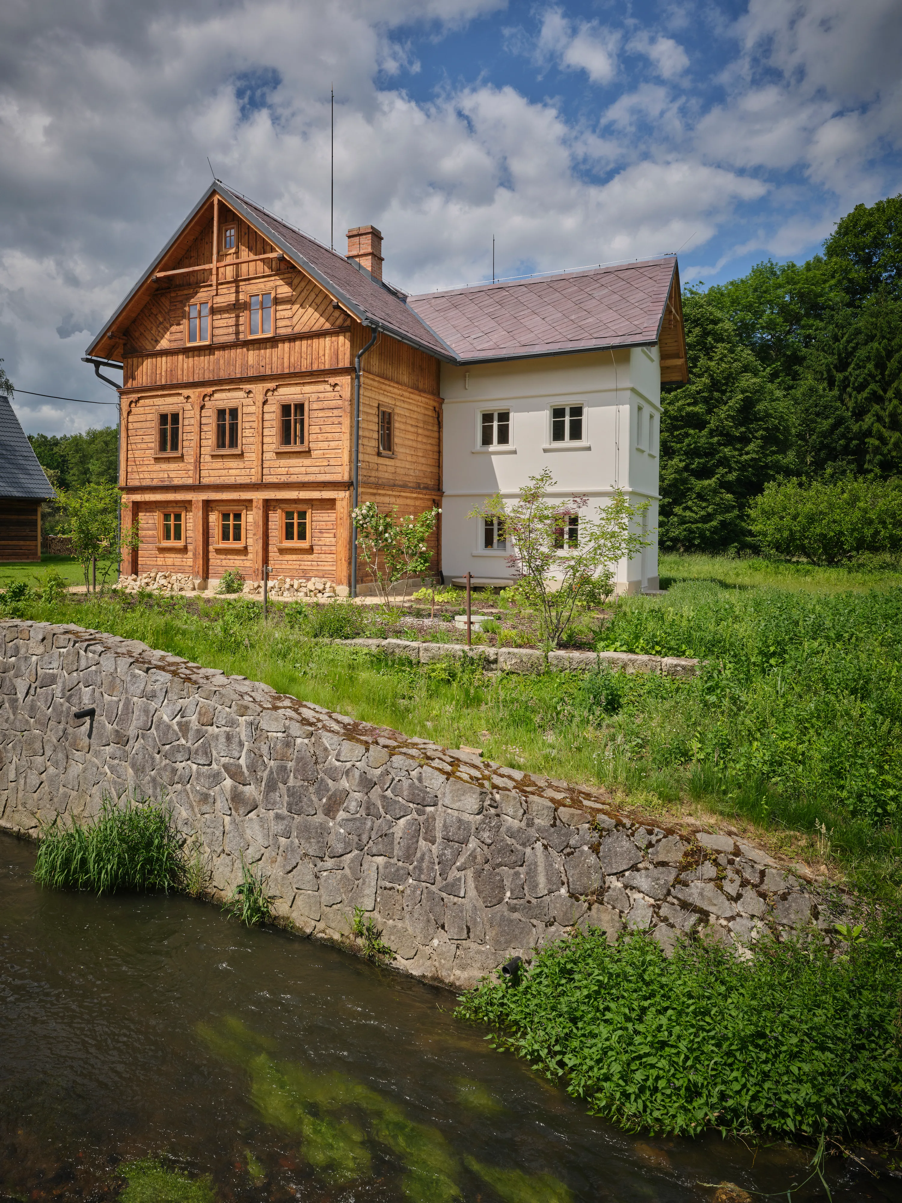 Dům nad kamennou zdí u říčky Svitavky